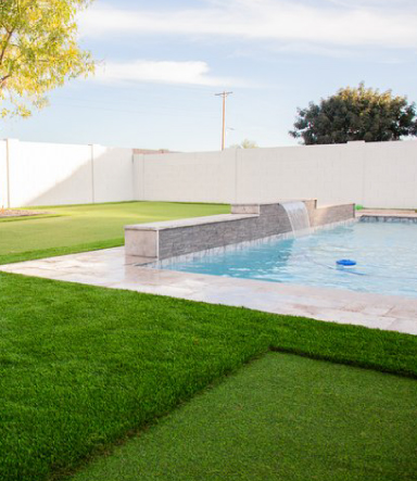 Arizona Inground pool with modern waterfall and artificial turf grass